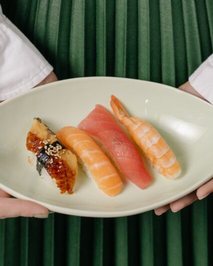 Woman Holding Plate of Sushi | Uwajimaya